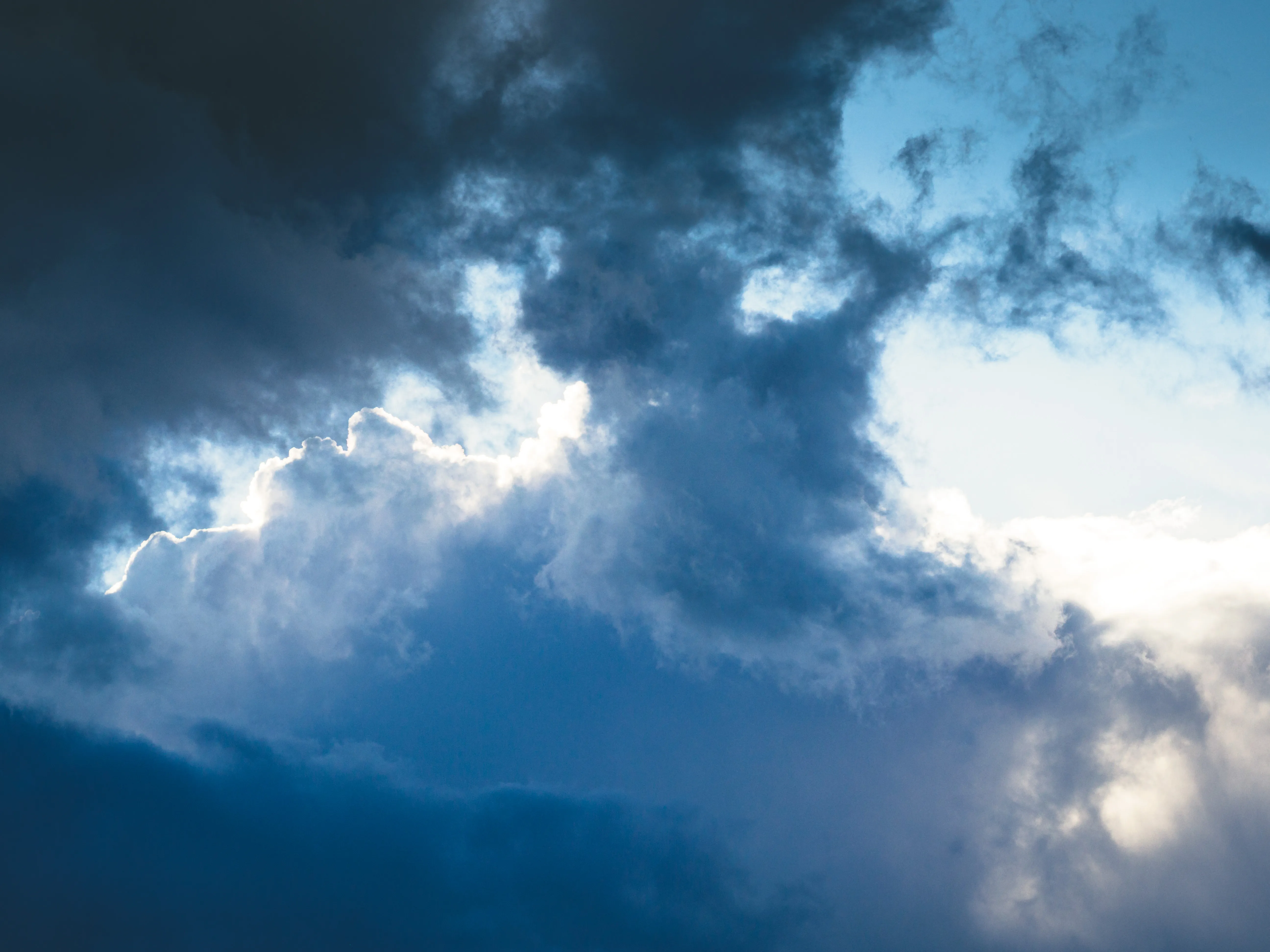 Dramatic storm clouds with sunlight breaking through, showcasing the type of weather conditions PhotoWeather helps photographers capture