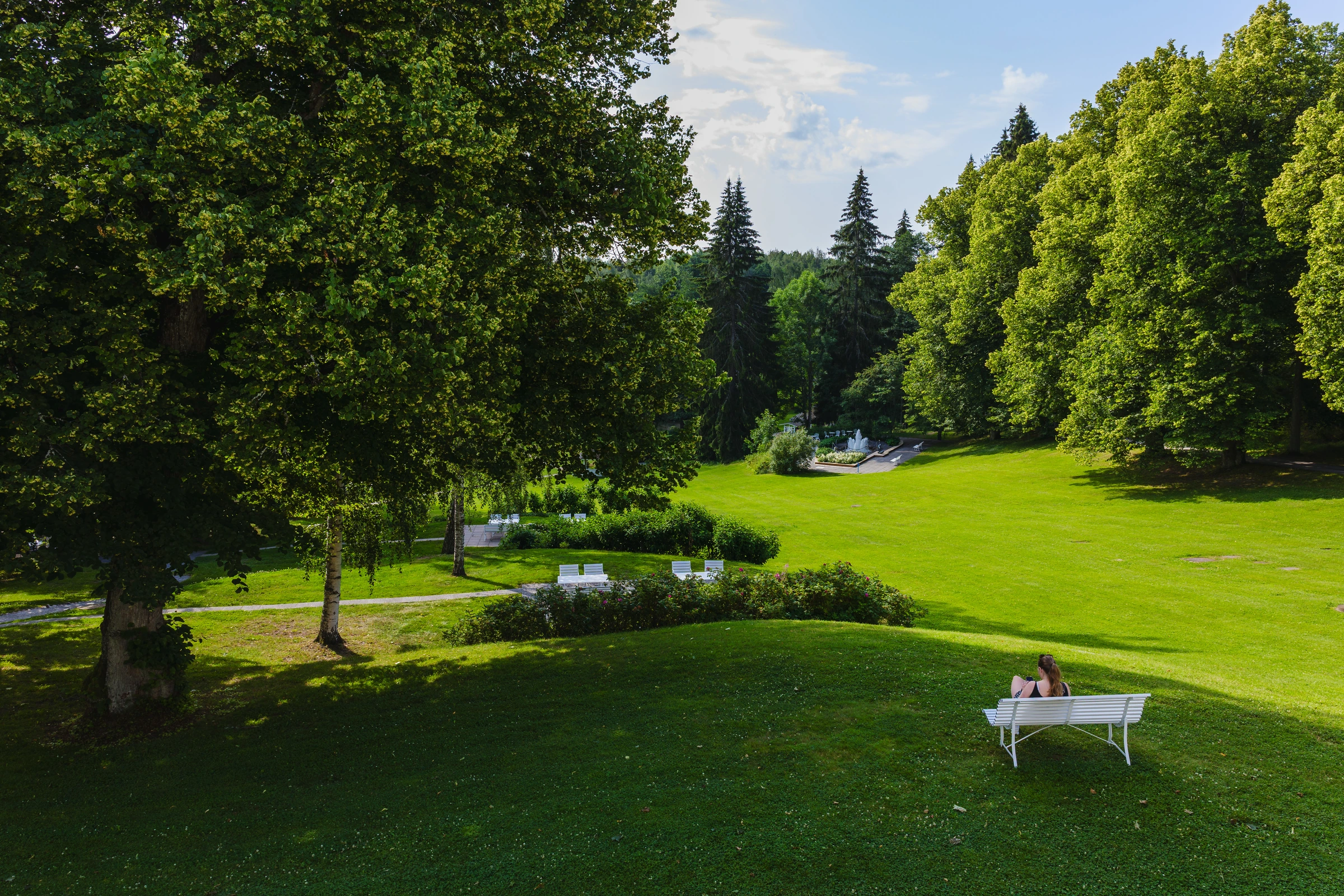 A bright sunny morning with soft light over a lush green park scene.